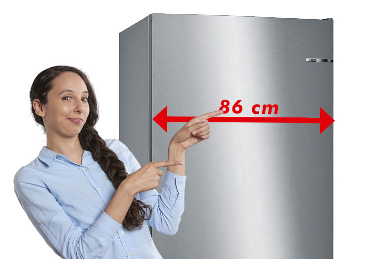 Mujer se&ntilde;alando a un frigor&iacute;fico combi marca Bosch de 86 cm de ancho.